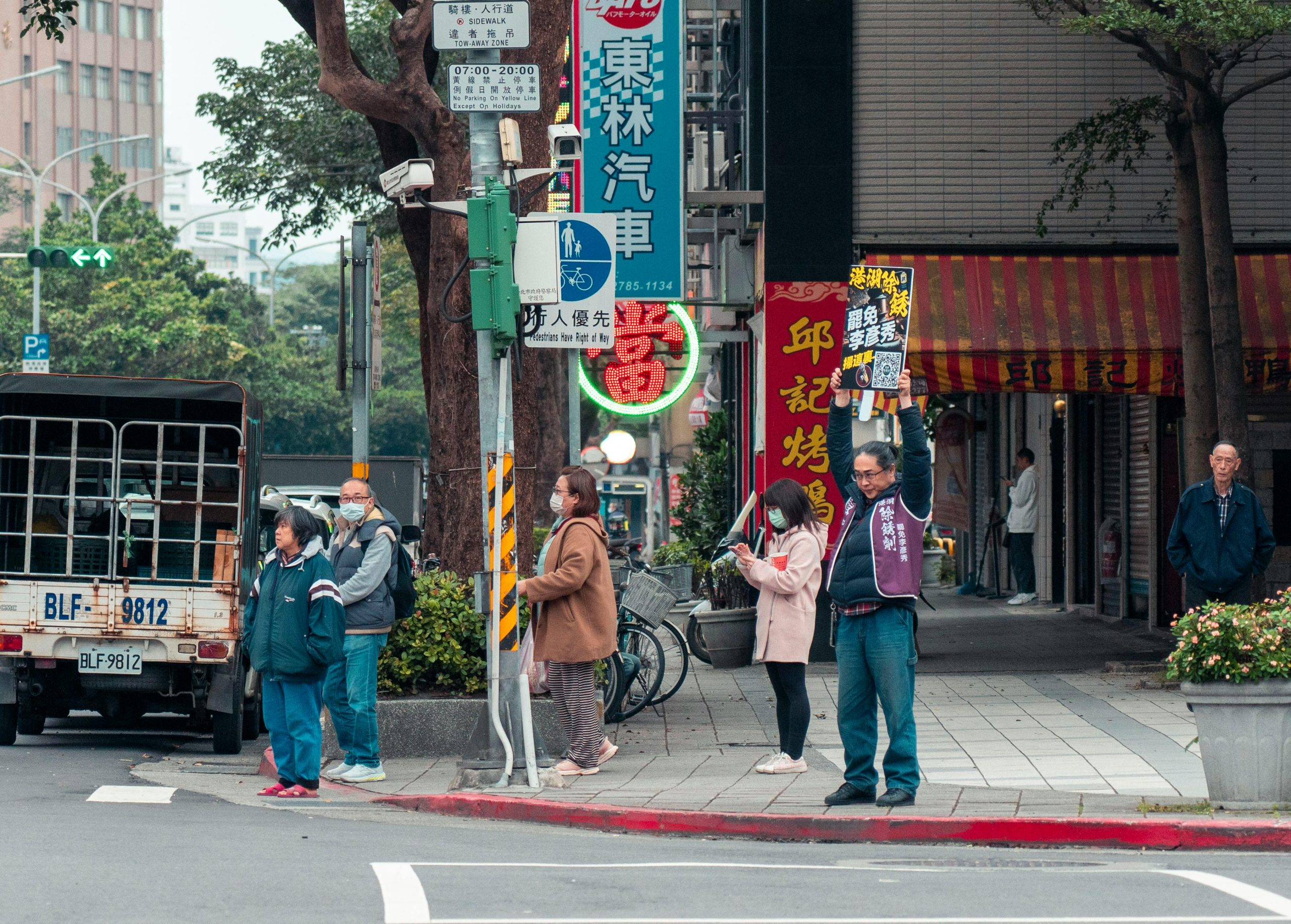 Urban street scene in Taipei, Taiwan with pedestrians and colorful signs.
